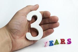 Hands on a white background holding number 3 photo