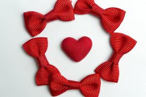 Red heart in the center on the sides of the bows on a white background. photo