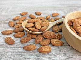 almond on wooden table with spoon, Almond in wooden bowl. photo