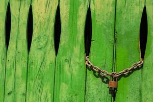 Green door in the stone wall with lock locked Spain. photo