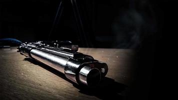 cinemagraph de la fumée émise par le canon d'un pistolet en argent de 9 mm posé sur une table en bois video