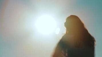 Silhouette of a carefree unrecognizable girl dancing towards the sun video
