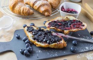 French croissants with blueberry jam and fruit. Close up shot