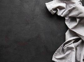 Grey linen tablecloth on a black background countertops. photo
