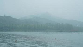 The beautiful lake landscapes in the Hangzhou city of the China in spring with the peaceful lake and fresh green mountains photo