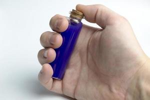 Hand Holding Test tubes with blue liquids photo