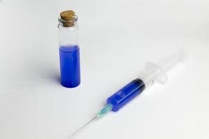 The flask and syringe with blue solution in laboratory science. photo