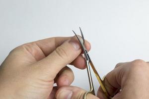 A close up of a woman's hand clipping her fingernails