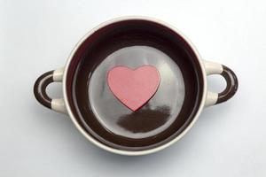 Big red heart at the bottom of the tureen. photo