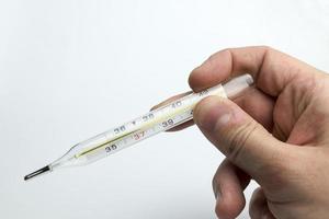 Hand holds a thermometer. photo