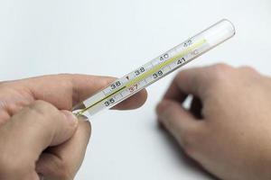 Hand holds a thermometer. photo
