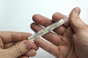 Hand holds a thermometer. photo