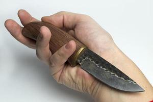 Hand on a white background holding a knife. photo