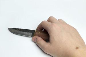 Hand on a white background holding a knife. photo