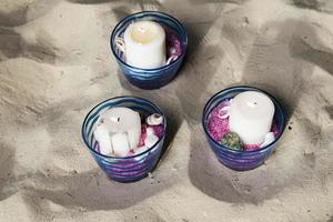 Three candles in the sand. photo