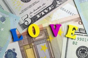 The word love is on the banknotes of colored letters. photo