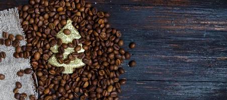 A toy Christmas tree in coffee beans on a wooden background, top view. photo