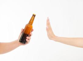 female hand reject a bottle of beer isolated on white background.anti alcohol concept. Copy space photo