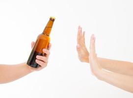 mano femenina rechazar una botella de cerveza aislado sobre fondo blanco concepto anti alcohol. copia espacio foto