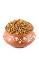Fenugreek seeds in clay pot isolated on white background photo