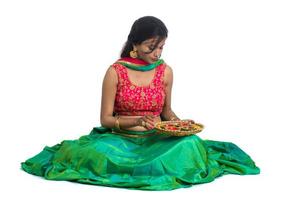 Retrato de una niña tradicional india sosteniendo diya, niña celebrando el diwali o deepavali con la celebración de la lámpara de aceite durante el festival de la luz sobre fondo blanco. foto