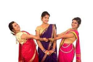 Hermosas niñas indias tradicionales en sari posando sobre fondo blanco. foto