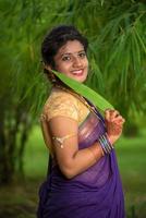 Indian Traditional Beautiful young girl in saree posing outdoors photo