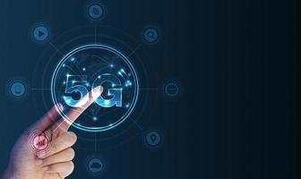 Hand pointing 5G network wireless systems and internet of things with man touching with wireless high-speed Internet communication network background photo