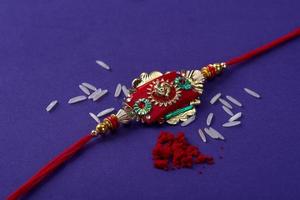 Raksha Bandhan Rakhi with rice grains and kumkum. An Indian festive background. Traditional Indian wrist band which is a symbol of love between Brothers and Sisters. photo