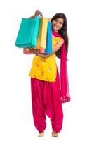 Beautiful Indian young girl holding and posing with shopping bags on a white background photo