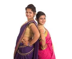Hermosas niñas indias tradicionales en sari posando sobre fondo blanco. foto