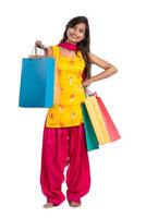 Beautiful Indian young girl holding and posing with shopping bags on a white background photo