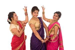 Hermosas niñas indias tradicionales en sari posando sobre fondo blanco. foto