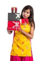 Portrait of young happy smiling Indian Girl holding gift boxes on a white background. photo