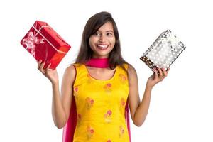 Portrait of young happy smiling Indian Girl holding gift boxes on a white background. photo