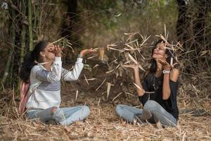 Happy girls playing with fallen leaves in park photo