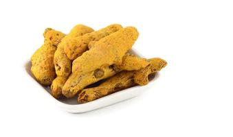 Dry Turmeric roots or barks in white plate isolated on white background photo