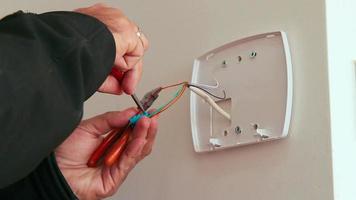 technicus die alarm van een slim huisbeveiligingssysteem installeert of repareert