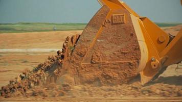 Tractor with a bulldozer moving soil at a construction site video