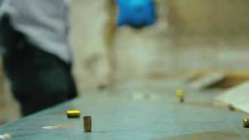 cartuchos de bala de pistola vazios caindo e atingindo uma mesa de madeira em um campo de tiro