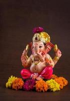 Hindu God Ganesha. Ganesha Idol on dark wooden background.