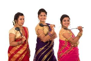 Young Traditional Indian Girls holding kitchen utensil on white background photo