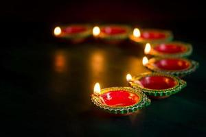 Happy Diwali - Clay Diya lamps lit during Diwali celebration. Greetings Card Design of Indian Hindu Light Festival called Diwali photo