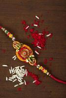 Indian festival Raksha Bandhan background with an elegant Rakhi, Rice Grains and Kumkum. A traditional Indian wrist band which is a symbol of love between Brothers and Sisters. photo