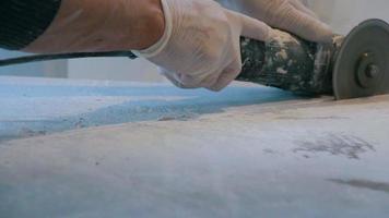 Worker cutting a tile using an angle grinder at construction site video