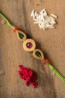 Indian festival Raksha Bandhan background with an elegant Rakhi, Rice Grains and Kumkum. A traditional Indian wrist band which is a symbol of love between Brothers and Sisters. photo