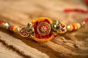 Indian festival Raksha Bandhan background with an elegant Rakhi, Rice Grains and Kumkum. A traditional Indian wrist band which is a symbol of love between Brothers and Sisters. photo