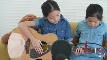 ragazza più grande con la sorella minore che usa il capo per cambiare la chiave della chitarra video