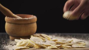 leckere rohe Ravioli mit Mehl und Basilikum auf Holztisch video