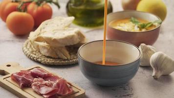 Serving salmorejo in a bowl, with various ingredients around. Salmorejo is a typical Andalusian dish, similar to gazpacho video